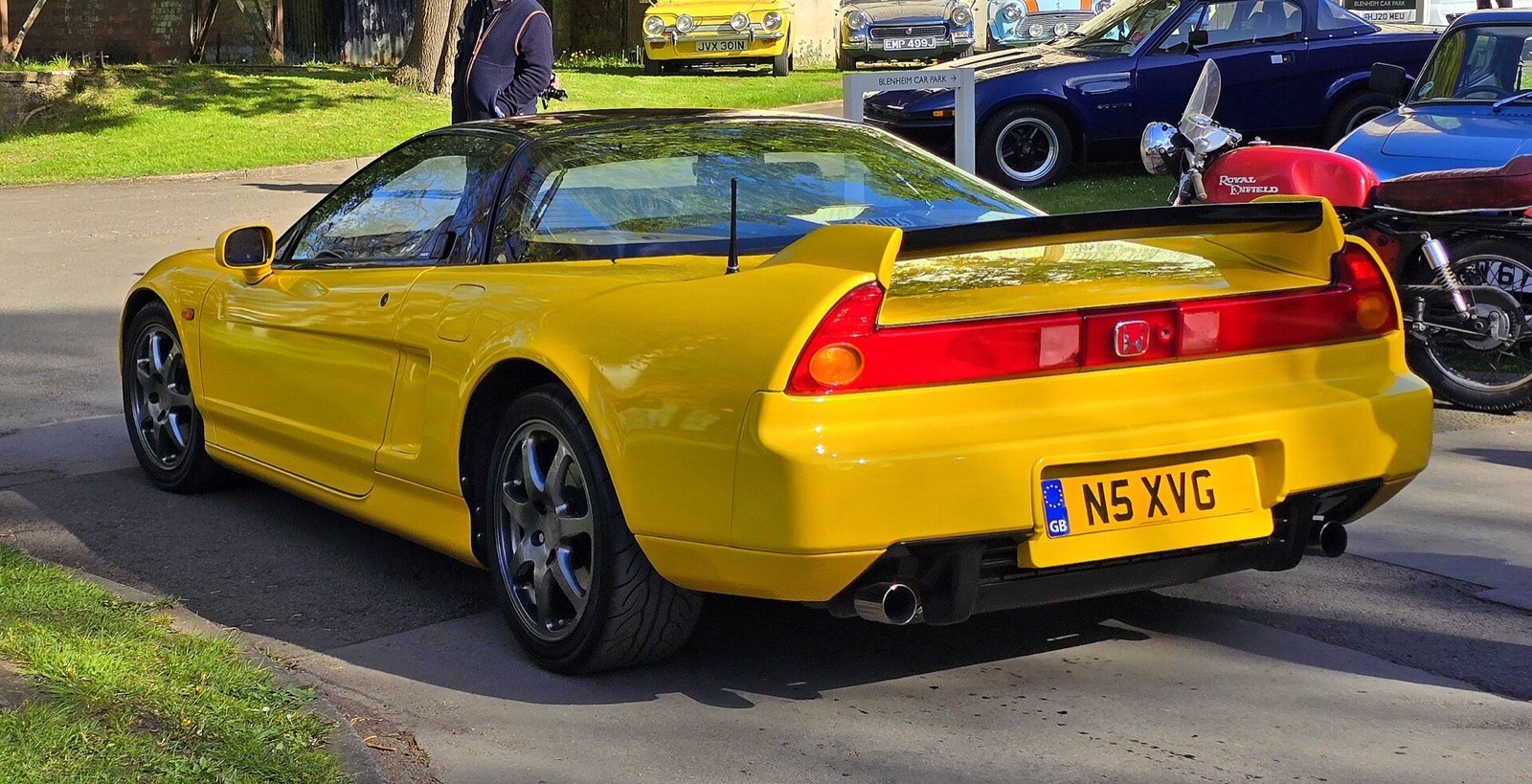Yellow Honda NSX rear three-quarter view showing the full-width taillight and rear spoiler